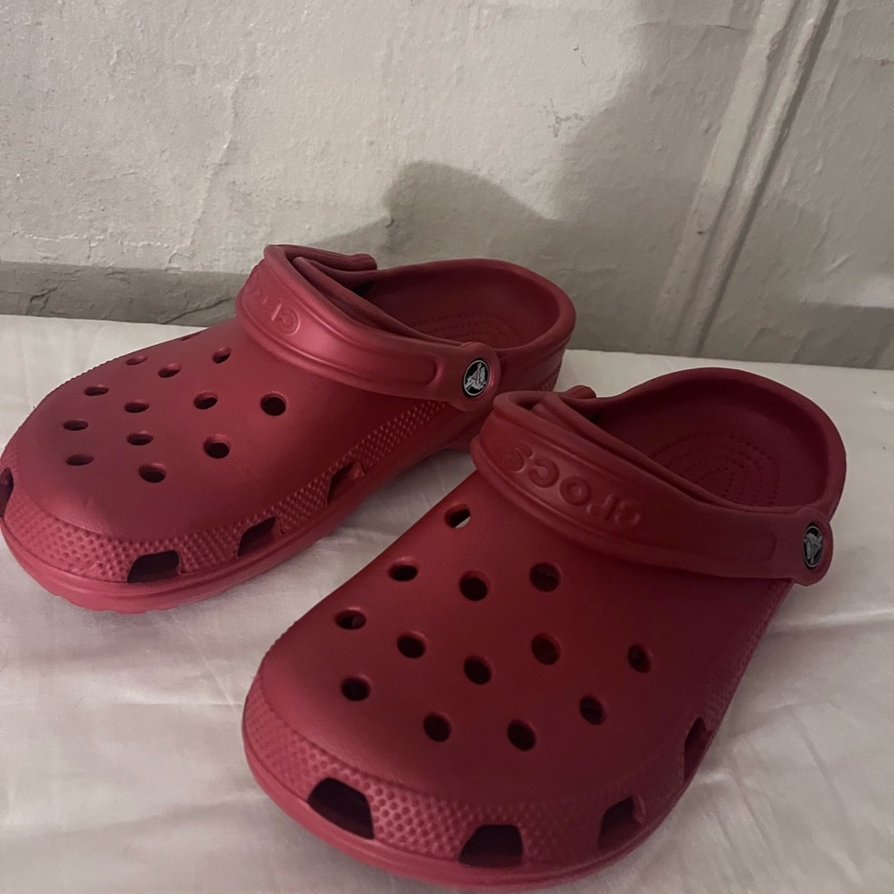 A pair of red crocs size 9 .